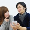 カップルが携帯を見る